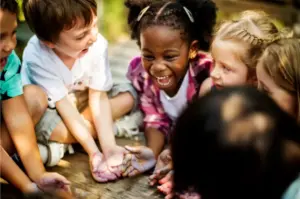 Crianças em roda brincando juntas, interagindo com alegria e cooperação em atividade coletiva na educação infantil.