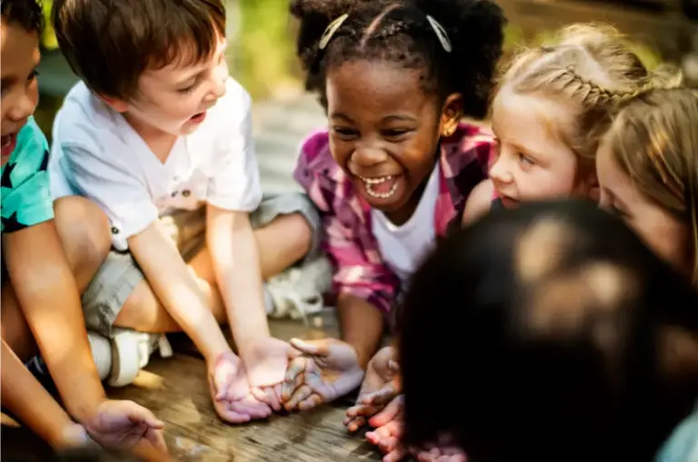 Crianças em roda brincando juntas, interagindo com alegria e cooperação em atividade coletiva na educação infantil.