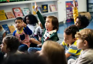 Crianças participam de atividade em sala de aula, estimulando a educação socioemocional, a interação e o desenvolvimento emocional infantil.